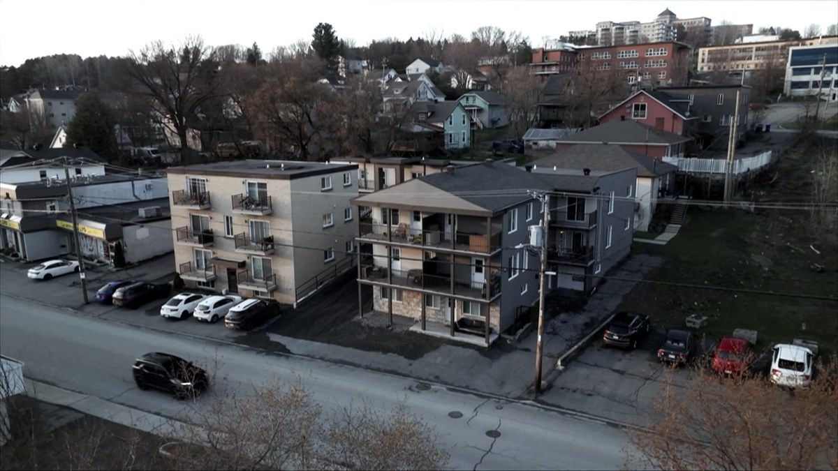 Saint-Georges de Beauce 街边几栋三四层的出租公寓楼，楼前停着车