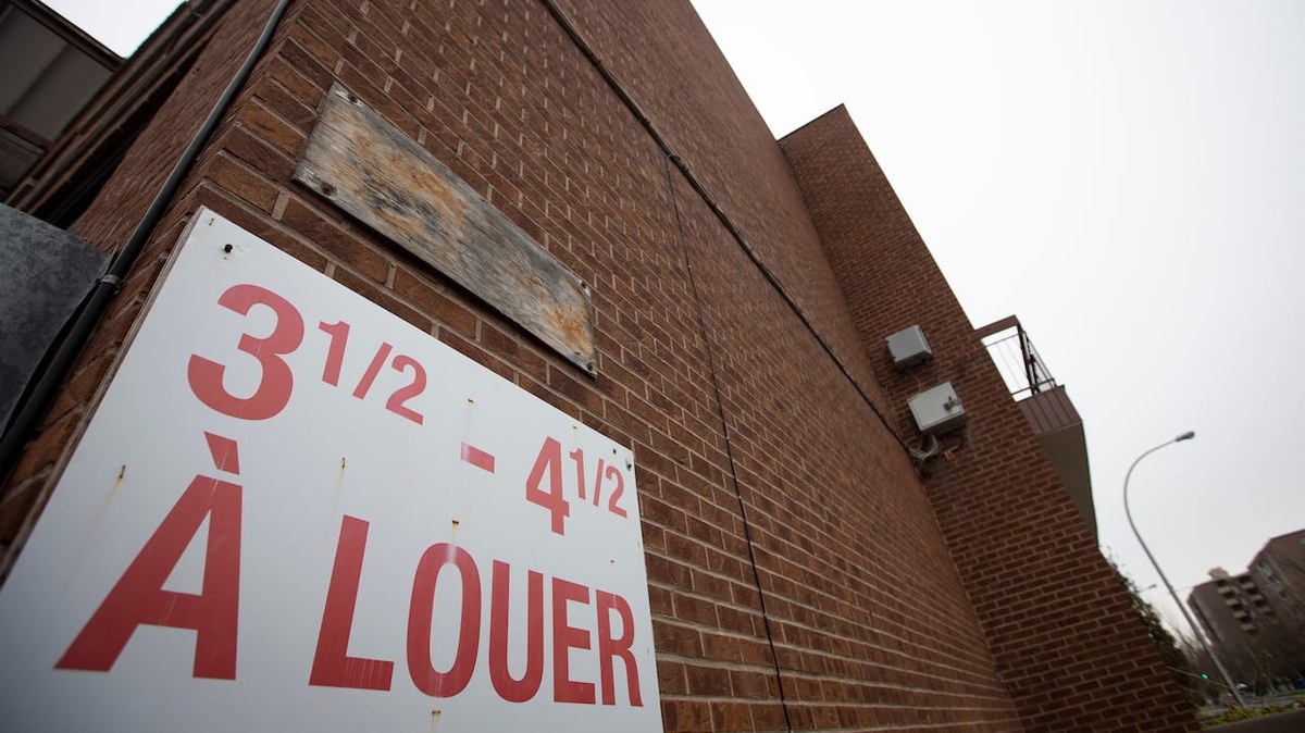 红砖公寓楼外墙上挂着白底红字的「3½ – 4½ À LOUER」招租牌