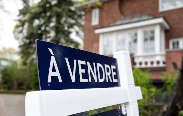 蒙特利尔一栋红砖住宅前的 À VENDRE 待售牌